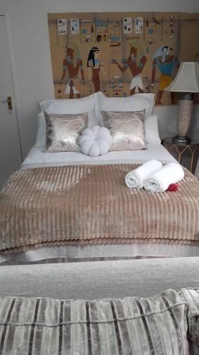 a bed with two towels and pillows on it at Villa Francisco Bed & Breakfast Solar Power in Germiston
