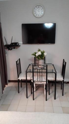 a table with two chairs and a clock on a wall at Villa Francisco Bed & Breakfast Solar Power in Germiston