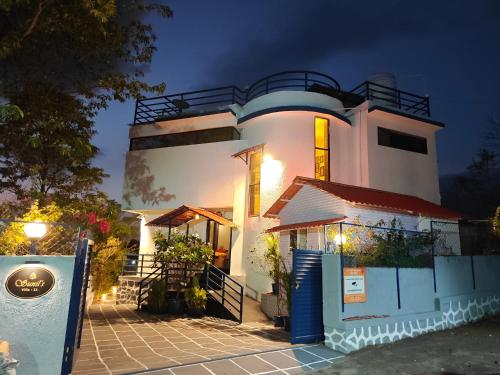 a white house with a sign in front of it at Sunils villa with private pool, Machan and play area in Karjat in Karjat