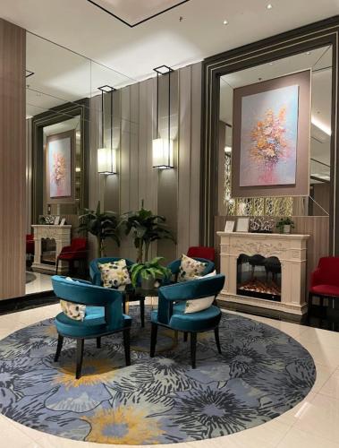 a lobby with chairs and a table and a fireplace at Anderson pakuwon 2 Bedroom 6 people stay in Surabaya