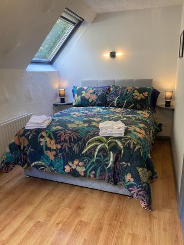 a bedroom with a large bed with a colorful bedspread at The Gallery Cottage in Castledawson