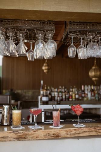a row of glasses on a bar with cocktails at Hotel Galfi - Boutique & Adults Only in San Antonio