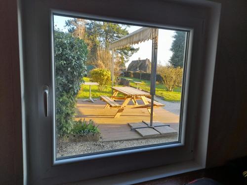 a view of a picnic table from a window at Authenticity Preserved in Brionne