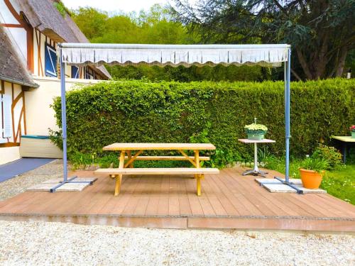 a wooden picnic table with a canopy and a table at Authenticity Preserved in Brionne