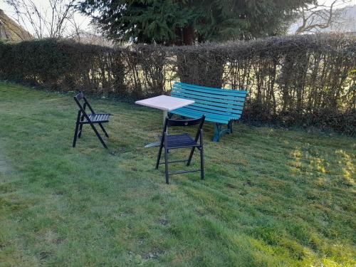 two chairs and a table in the grass at Authenticity Preserved in Brionne