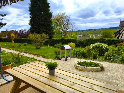 a wooden picnic table sitting in a garden at Authenticity Preserved in Brionne