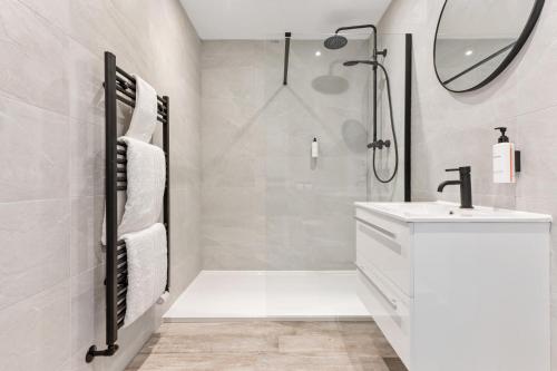 Un baño blanco con lavabo y ducha. en Mode Pleasure Beach Apartments, en Blackpool