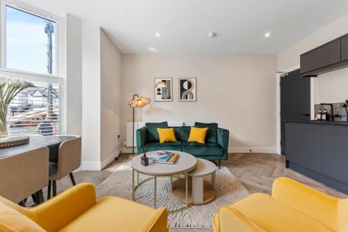 a living room with a green couch and a table at Pleasure Beach Apartments by Central Beach Leisure in Blackpool