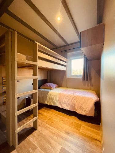 une chambre avec deux lits superposés et une fenêtre dans l'établissement Bassin d'Arcachon - Chalet VIP 5 personnes, à La Teste-de-Buch