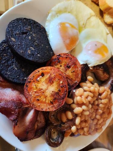 a plate of food with eggs beans and mushrooms at Blea Tarn Farmhouse B&B in Ambleside