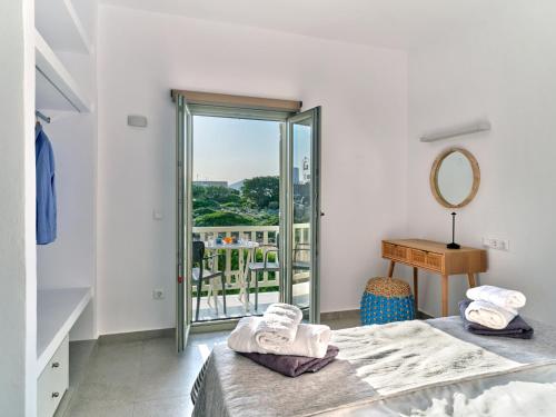 a bedroom with a bed and a mirror and a table at Ilios 2 Apartment Paros Naousa in Naousa