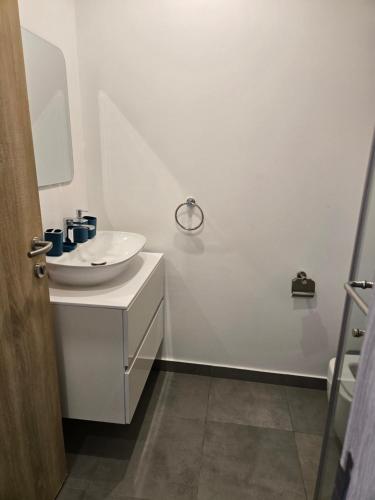 a white bathroom with a sink and a mirror at Nova luxe 2 Bed Executive Stay in Accra