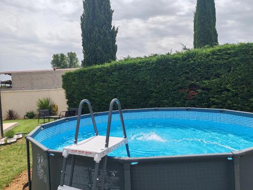 - une piscine avec une chaise dans l'établissement Villa Moderne Piolenc, à Piolenc