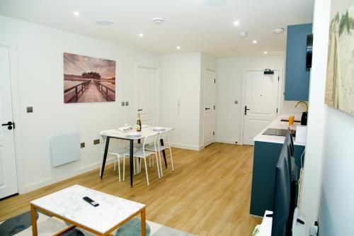 a kitchen and dining room with a table and chairs at Jazreal Luxury Apartment - Leeds City Centre in Leeds
