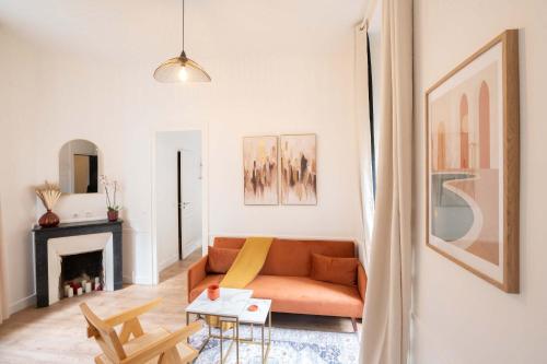 - un salon avec un canapé orange et une cheminée dans l'établissement Logement terrasse metro Pierre Lachaise - 3P, à Paris