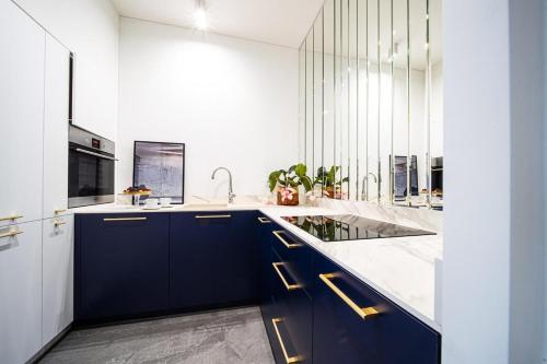 a kitchen with blue cabinets and a sink at Art Deco Retreat - Łódź Centrum in Łódź