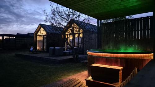 a hot tub in a backyard with a green light at Domki Wilków z widokiem na Łysicę in Wilków