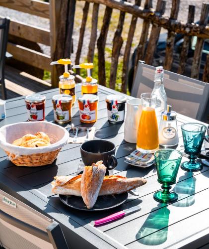 una mesa con un plato de comida y bebidas. en La Ferme de Jean entre lacs et montagnes, en Saulxures-sur-Moselotte
