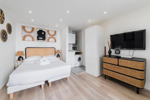 une chambre avec un lit et une télévision à écran plat dans l'établissement Elegant Studio voltaire- Paris 11 - 2P, à Paris