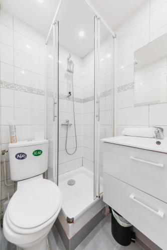 une salle de bain blanche avec toilettes et douche dans l'établissement Elegant Studio voltaire- Paris 11 - 2P, à Paris