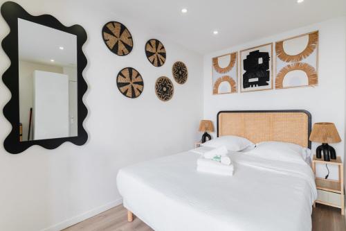 - une chambre dotée d'un lit avec un miroir et des horloges murales dans l'établissement Elegant Studio voltaire- Paris 11 - 2P, à Paris