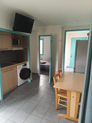 une cuisine et une salle à manger avec une table et un réfrigérateur dans l'établissement Logement Lazuli, à Argelès-sur-Mer