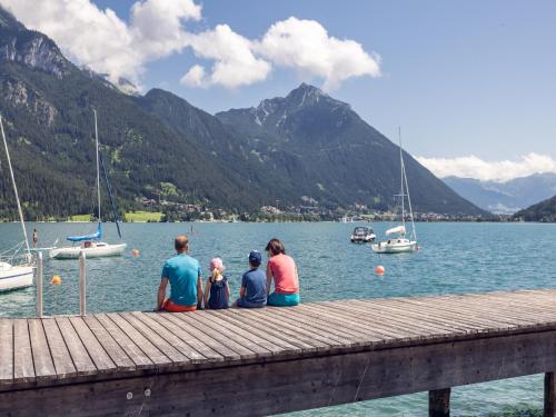 a group of people sitting on a dock overlooking a lake at Apartment at the Achensee in Achensee
