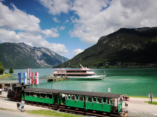 a train station with a cruise ship in the water at Apartment at the Achensee in Achensee