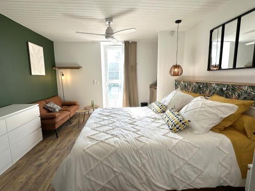 a bedroom with a large white bed and a couch at Le petit Arrigade in Mimbaste