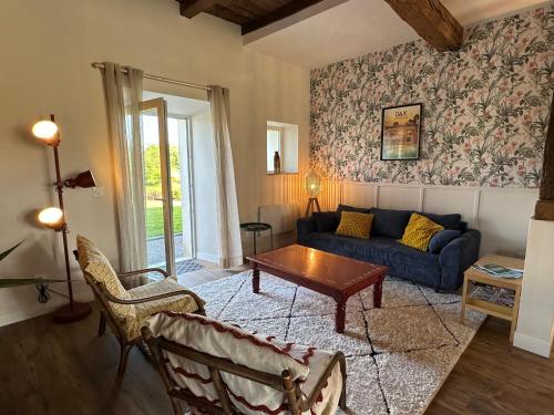 a living room with a blue couch and a table at Le petit Arrigade in Mimbaste