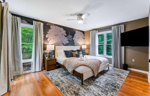 Schlafzimmer mit einem großen Bett und Fenstern in der Unterkunft Dine Outdoors, Dream Indoors 5BR in East Stroudsburg