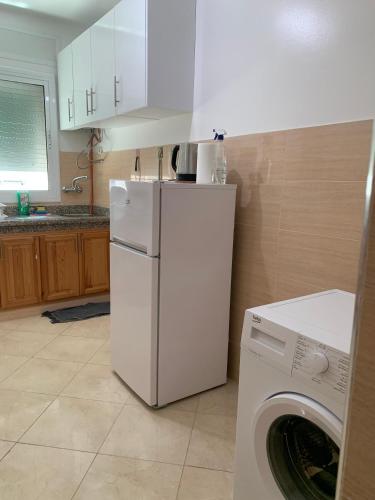 a kitchen with a white refrigerator and a washing machine at Tanger Relax Appartement in Tangier