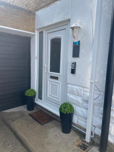 a front door of a house with two potted plants at Haven Vale in Stockton-on-Tees