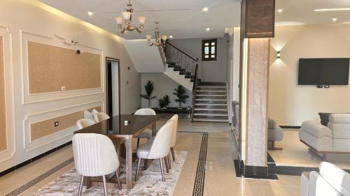 a dining room with a table and white chairs at Queen M in Marsa Matruh