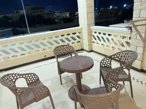 a table and four chairs on a balcony with a window at Queen M in Marsa Matruh