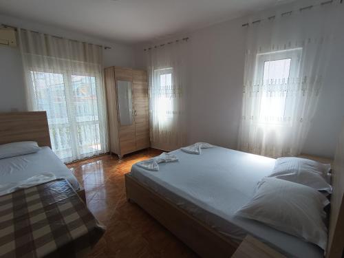 a bedroom with two beds and two windows at Accommodation Milla in Ulcinj