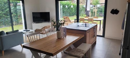 un salon avec une table et des chaises en bois dans l'établissement Villa Voltaire, à Seignosse