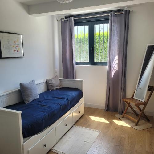 une chambre avec un lit avec une couverture bleue dans l'établissement Villa Voltaire, à Seignosse