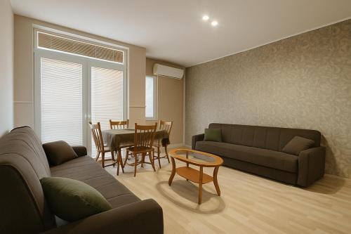 a living room with a couch and a table at Struga Rooms-Dhoma-Sobi in Struga