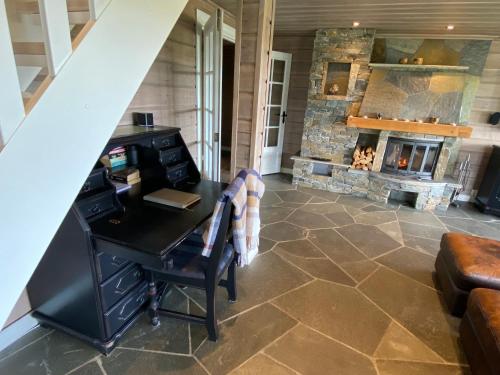 an attic office with a desk and a fireplace at Bjørnebuhytten, Geilo, 13 sengeplasser med privat Jacuzzi og el-bil-lading in Geilo