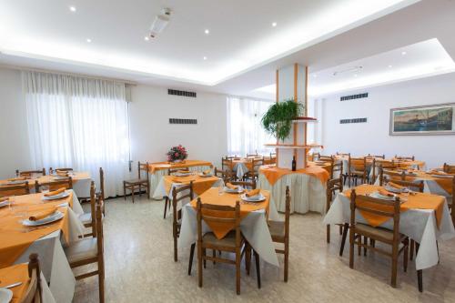 a dining room with wooden tables and chairs at Hotel Graziana in Riccione