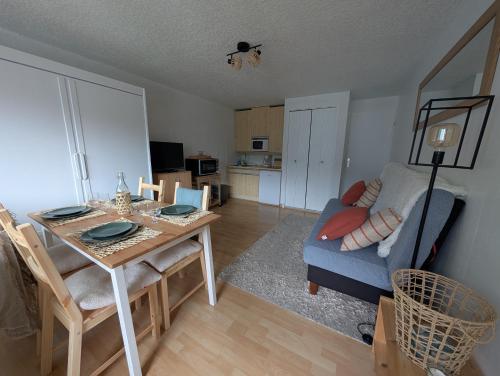 un salon avec une table et un canapé bleu dans l'établissement Appartement confortable Saint Lary village, à Saint-Lary-Soulan