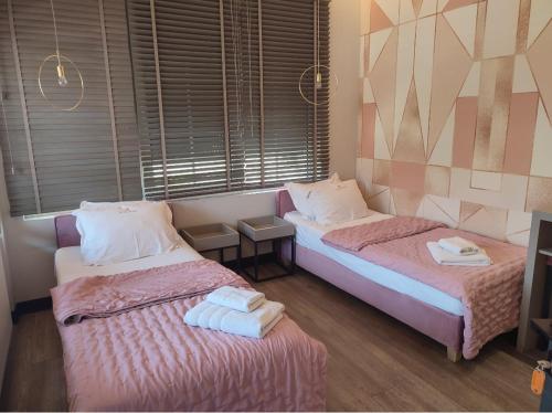 a room with two beds with towels on them at Avenue Luxury Apartments in Alexandroupoli