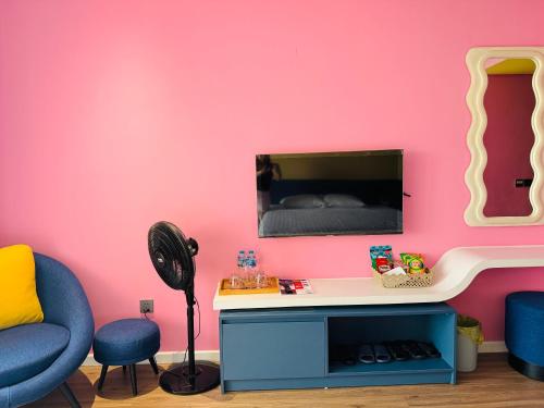 a room with a desk and a pink wall at FLAMINGO Ibiza HaiTien - Ivy Abtel in Thanh Hóa