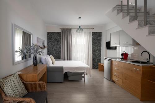 a bedroom with a bed and a kitchen with a staircase at Leon Villas in Nikiti