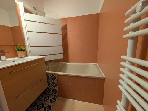 une salle de bain avec une baignoire et un lavabo dans l'établissement Appartement confortable Saint Lary village, à Saint-Lary-Soulan