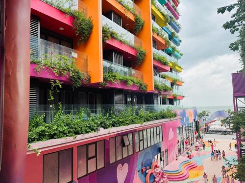 a colorful building with plants on the side of it at FLAMINGO Ibiza HaiTien - Ivy Abtel in Thanh Hóa