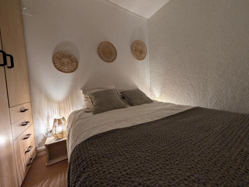 une chambre avec un lit et un mur blanc dans l'établissement Appartement confortable Saint Lary village, à Saint-Lary-Soulan