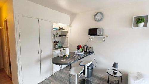 une chambre avec une table, deux chaises et une horloge dans l'établissement Chez loverchy, à Annecy