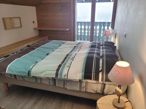 une chambre avec un lit et une lampe sur une table dans l'établissement Duplex vue sur montagne, à Saint-Gervais-les-Bains